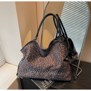 Detail of leopard print tote bag featuring Gugugugu embroidery and side drawstring