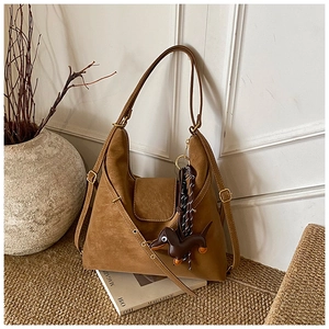Brown vintage suede hobo bag with adjustable strap and cute dachshund bag charm detail