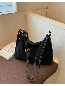 Detail of vintage black tote bag with contrast white stitching and gold hardware buckle