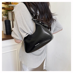 Close-up of black glossy PU leather baguette bag with Fashion & Bags printed text