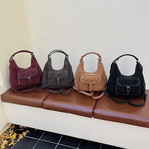 Detail view of four vintage suede convertible backpacks in burgundy, grey, camel and black