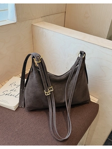 Detailed macro view of retro brown faux suede tote bag with gold metal buckle and strap
