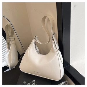 Detailed view of cream baguette bag with silver FASHION & BAGS logo and zipper closure