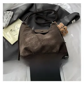 Détail du sac cabas vintage en similicuir marron foncé avec pendentif ours en peluche