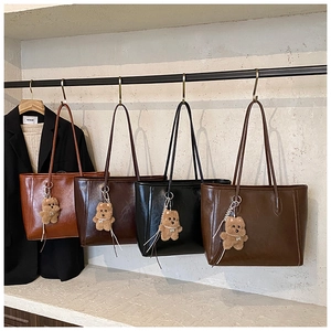 Présentation de sacs cabas rétro en similicuir en quatre couleurs avec breloques d'ours