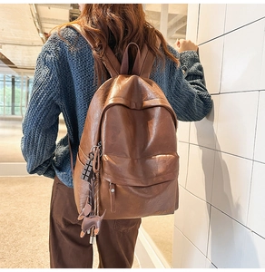 Détail du sac à dos en cuir marron vintage avec charms cerf et chocolat mignons