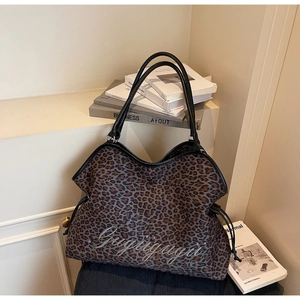 Detail of leopard print tote bag with Gugugugu embroidery and black leather straps