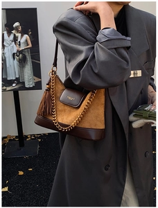 Détail du sac bandoulière vintage en daim matelassé avec chaîne dorée et gland