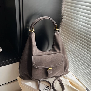 Detail of hobo bag with front pocket, gold buckle, and matte dark taupe leather texture