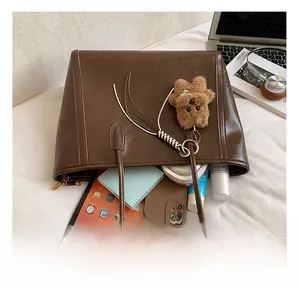 Vue intérieure du grand sac cabas marron montrant sa capacité pour tablettes et objets