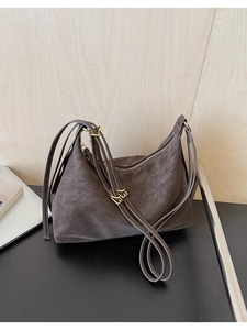 Detail of vintage charcoal hobo bag showing faux suede texture and gold-tone metal buckles