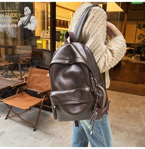 Gros plan d'un sac à dos vintage en cuir PU marron avec un charmant pendentif lapin