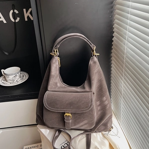 Detail of taupe hobo bag showing contrast stitching and buckle front pocket