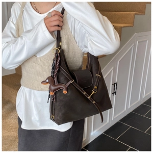 Detail of dark brown leather hobo bag with contrast stitching and dachshund charm