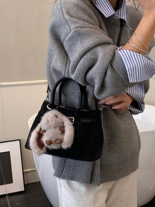 Chic black velvet bucket bag with plush rabbit pendant and silver metallic hardware clasp