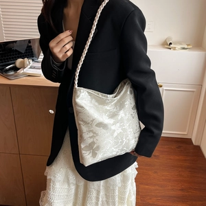 Silver grey butterfly print shoulder bag with white woven rope strap on female model