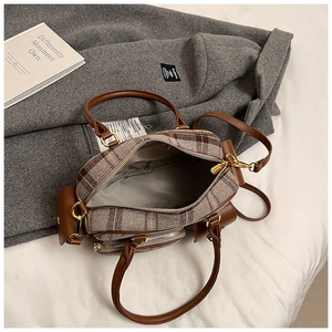Vue détaillée du tissu à carreaux rétro et de la sangle en cuir marron du sac à main