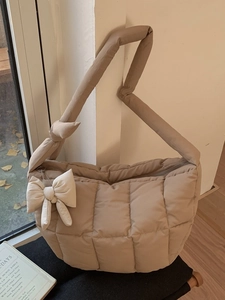 Sac à main matelassé beige avec bandoulière nouée et un joli charm en forme de nœud