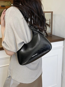 Fashionable black faux leather baguette shoulder bag with white lettering for women