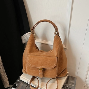 Macro shot of light brown lychee textured PU leather backpack with white stitching details