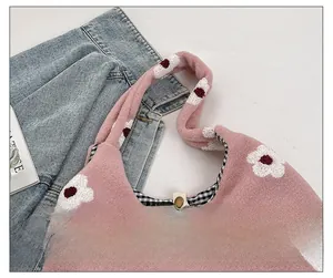 Detail of pink plush tote bag showing internal black and white gingham lining and clasp