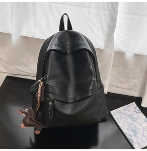 Détail du sac à dos noir en cuir PU avec pendentif teckel et logo en relief