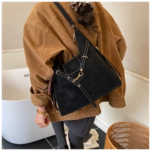 Detail of black matte tote bag featuring white contrast stitching and gold hardware accents