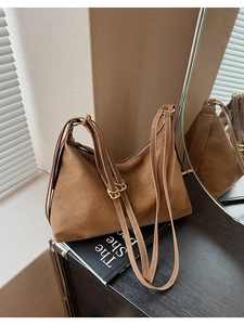 Detail of caramel suede Hobo bag with adjustable straps and gold-tone hardware detail