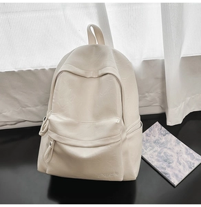 Détail d'un sac à dos en cuir blanc crème avec texture et poche avant zippée