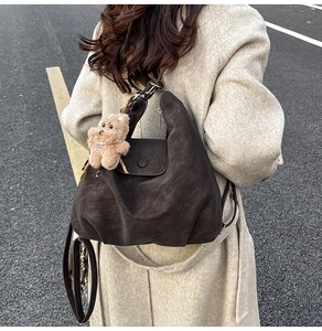 Detailed back view of a dark brown suede leather backpack with cute teddy bear charm