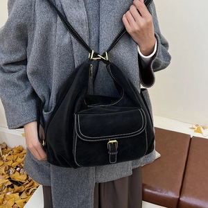 Detail of vintage black leather tote featuring contrast stitching and gold metal hardware