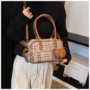Détail du sac à carreaux rétro avec poignées en cuir et ferrures en métal doré