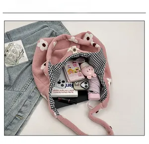 Interior view showing capacity of pink plush floral tote bag with items and checkered lining
