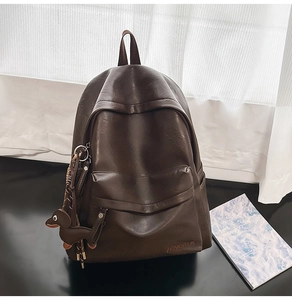 Détail du sac à dos en cuir PU marron doux avec design minimaliste et porte-clés chien