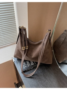 Detail of vintage brown textured leather tote with adjustable strap and golden hardware