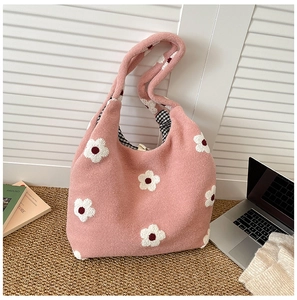 Detail of pink plush tote bag with white flower patterns and black checked lining