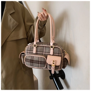 Détail du sac bowling à carreaux vintage avec bordure rose porté avec un trench