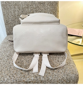Détail du fond renforcé et des bretelles réglables en cuir PU crème sur le sac à dos