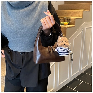 Détail du sac hobo marron foncé avec un charmant pendentif chiot en peluche et double zip