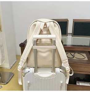 Détail du sac à dos en cuir crème avec sangle de bagage pour un voyage facile