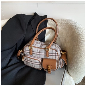 Détail du sac bowling multi-poches montrant le motif à carreaux et les anses en cuir