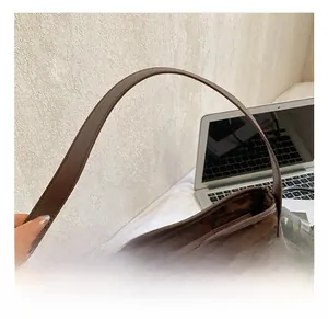 Detail shot of the brown leather handles and leopard print texture on a tote bag
