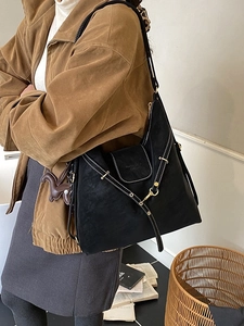 Black matte suede tote bag with white contrast stitching and a small horse charm