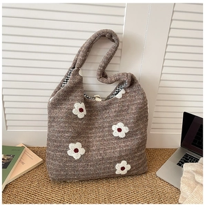Detail of plush brown tote bag with white 3D flowers and black check lining interior
