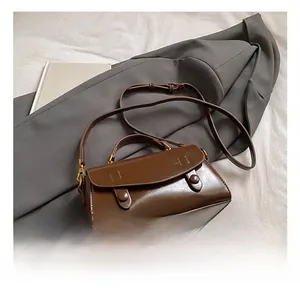 Detail of vintage brown crossbody bag with decorative buttons and adjustable strap