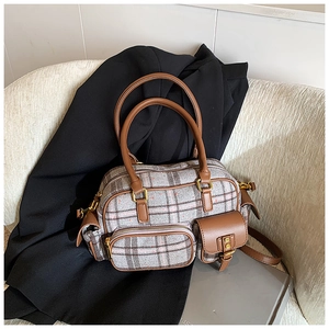 Détail du sac bowling à carreaux avec poignées en cuir marron et poches multiples