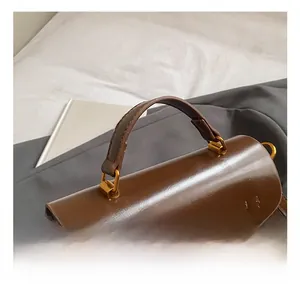 Detail of comfortable dark brown leather handle with premium gold square metal hardware