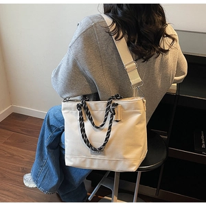 Détail du sac cabas en toile crème avec poignée à nœuds et bandoulière réglable