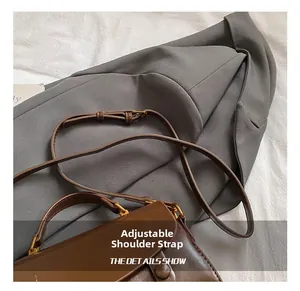 Detail of adjustable brown leather shoulder strap with elegant gold metal buckle hardware