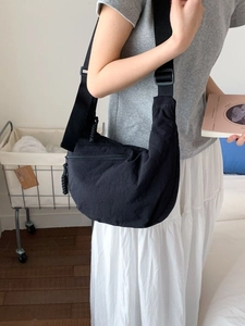 Sac bandoulière demi-lune noir avec large sangle réglable et poche zippée à l'avant